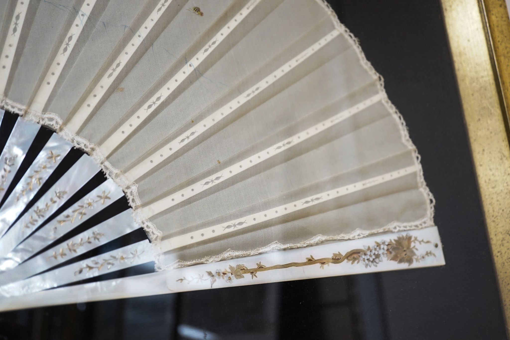 A framed 19th century French mother of pearl and painted silk fan, approx. 60cm long excl frame